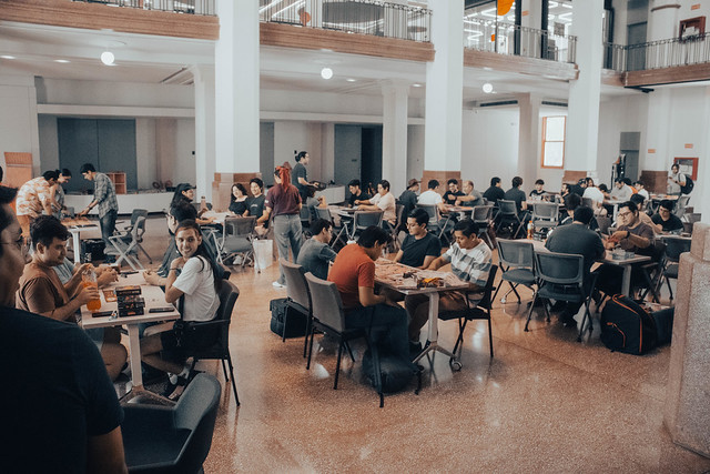 Interior del Antiguo Palacio Federal (sede del LabNL) con varias mesas y mucha gente jugando distintos juegos de mesa.